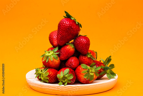 Fresh strawberries on orange background