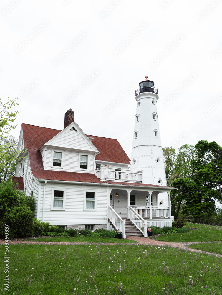 A portrait view of a historic lighthouse in on a cloudy day A portrait view of a historic lighthouse in on a cloudy day