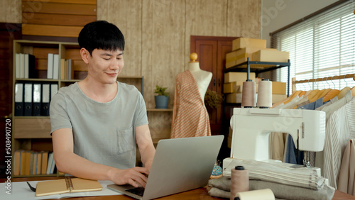 Young Man Asian LGBTQ Tailor Shop Owner,The typist chats with the customer about cutting the dress, with a happy face,Small business Professional Design clothes to sell online.