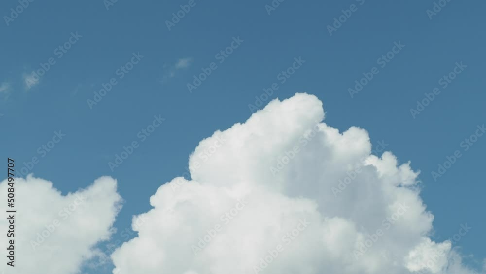 White cumulus clouds on a blue sky. High quality 4k footage