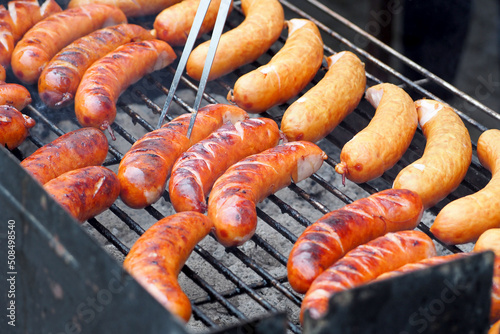 sausages are cooked on the grill . side view. barbecue