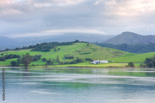 Farm next to the coast of Cantabria, with green pastures and soft light on the landscape