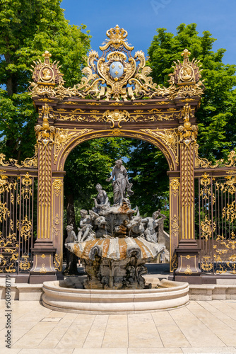 view of a gilded wrought-iron gate and Rococo fountain in the Stanislas Square of Nancy