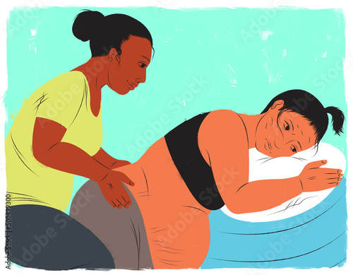 Pregnant woman in labor leaning against birthing ball while doula applies counter pressure photo