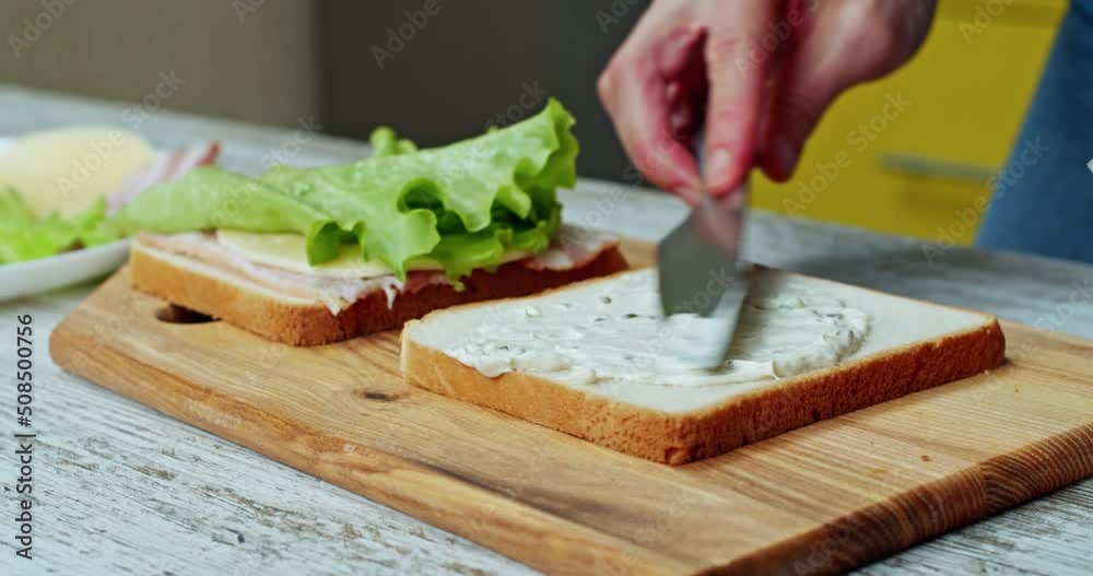 Cooking bread sandwich with salad, cheese and bacon by home kitchen. Cooking american meal for lunch Cooking bread sandwich with salad, cheese and bacon by home kitchen. Cooking american meal for lunch