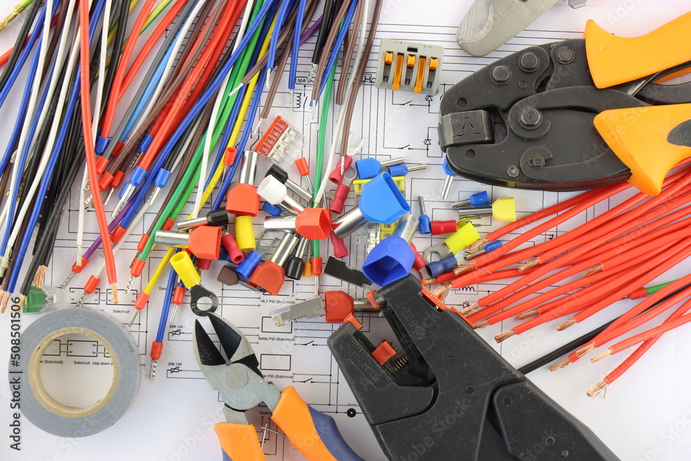 Tools for installing an electrical control panel in close-up on an electrical diagram.