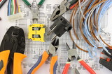 Tools for installing an electrical control panel in close-up on an electrical diagram.