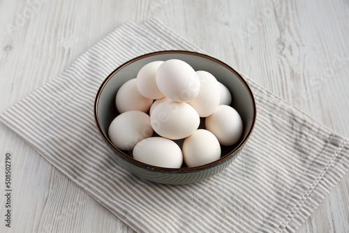 Raw Cage Free White Eggs in a Bowl, side view.