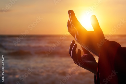 Silhouette human hands open palm up on sunset beach. Christian praying concept © BillionPhotos.com