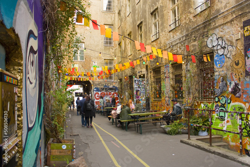Fototapet Haus Schwarzenberg - Street Art Alley with narrow passage next to a cafe leads t