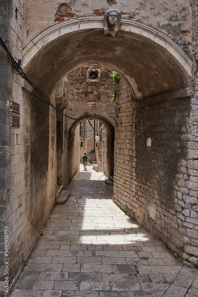 Obraz premium Sibenik, Croatia - May 26, 2022 - narrow old street and yard in Sibenik city, medieval zone