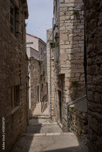 Fototapeta Naklejka Na Ścianę i Meble -  Sibenik, Croatia - May 26, 2022 - narrow old street and yard in Sibenik city, medieval zone