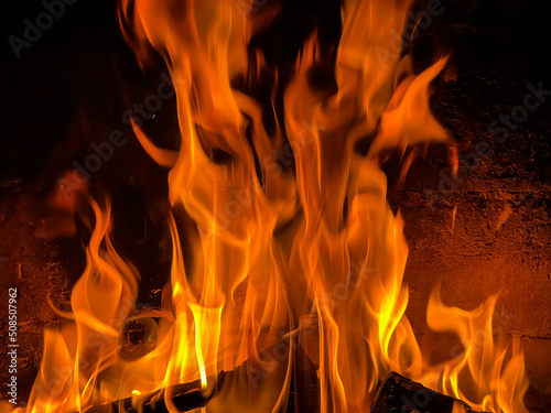 Flames of fire and hot coals of burned wood in the fireplace