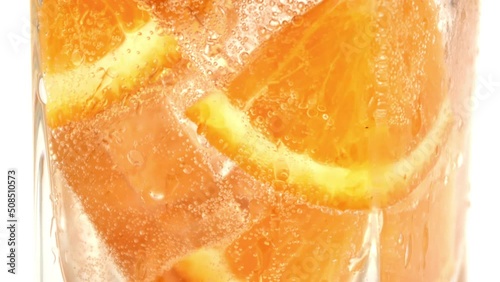 Glass cool carbonated summer cocktail fresh tropical orange slice with fizzy bubble macro shot