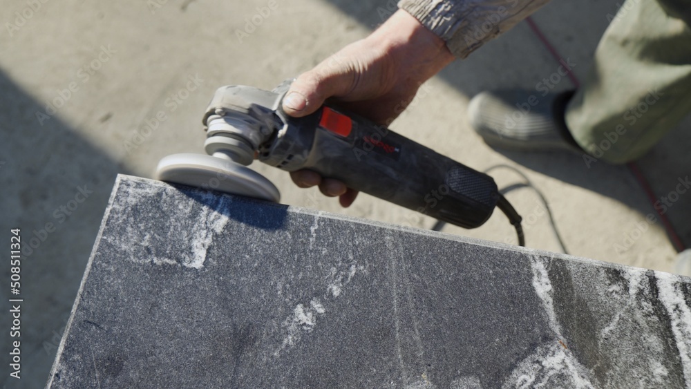 Work with a grinder on granite stone. Polishing of granite surface