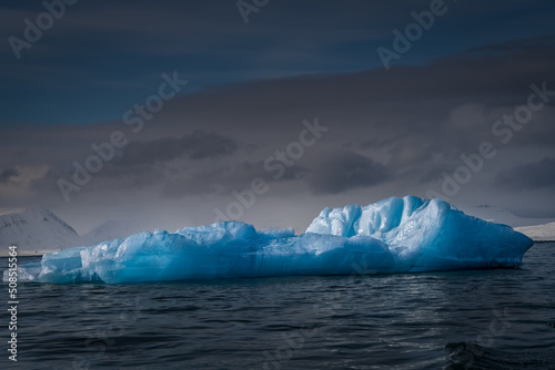 Fotobehang 2022-05-10 A LARGE PIECE OF BLUE TINTED SEA ICE FLOATING IN THE ARCTIC OCEAN NEA
