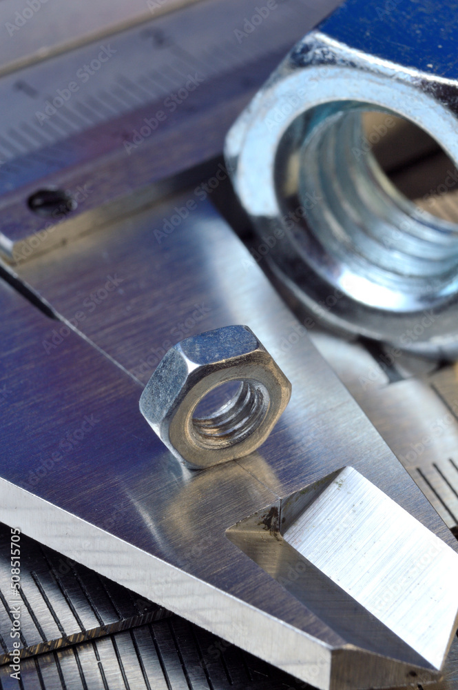 Accurate measuring tool caliper and metal ruler lie in place with nuts. close-up. Accurate measuring tool caliper and metal ruler lie in place with nuts. close-up.