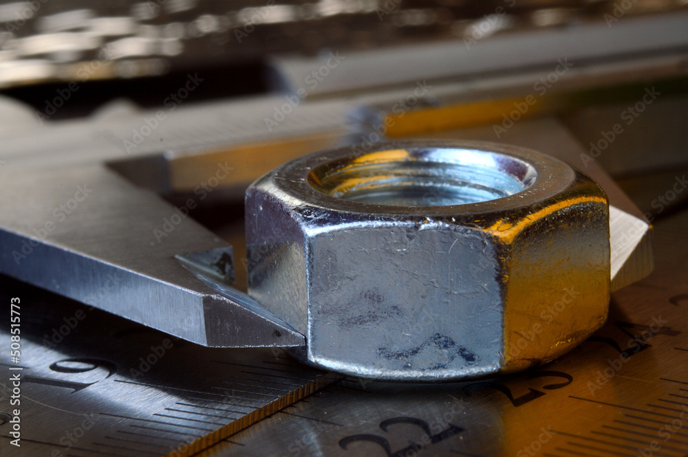 Accurate measuring tool caliper and metal ruler lie in place with nuts. close-up. Accurate measuring tool caliper and metal ruler lie in place with nuts. close-up.