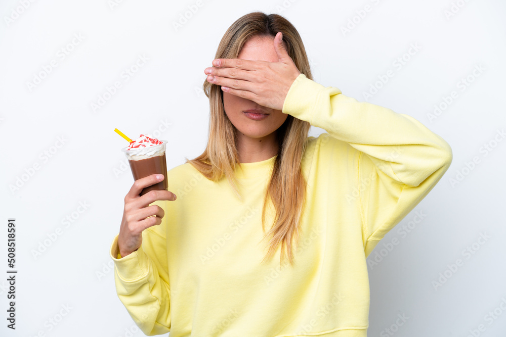Young Uruguayan woman holding Frappuccino isolated on white background covering eyes by hands. Do not want to see something Young Uruguayan woman holding Frappuccino isolated on white background covering eyes by hands. Do not want to see something