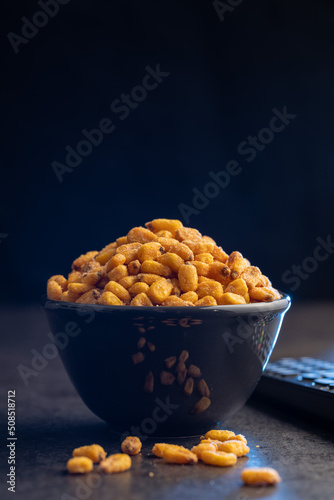 Fotografie, Obraz Roasted salted corn snack in bowl on black table.