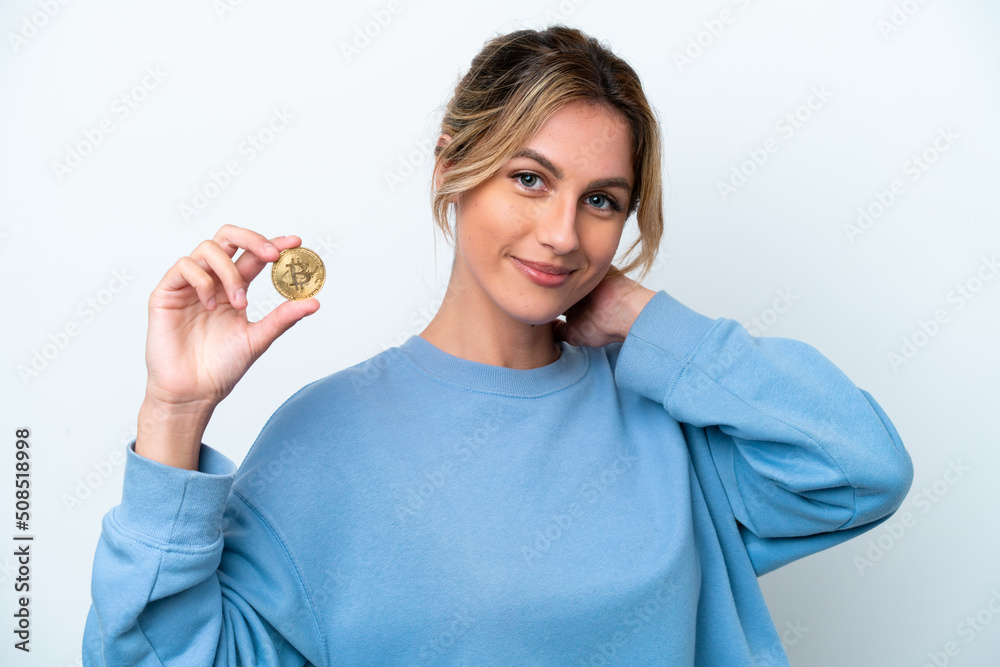 Young Uruguayan woman holding a Bitcoin isolated on white background laughing Young Uruguayan woman holding a Bitcoin isolated on white background laughing