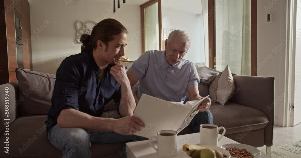 Father and son examining photos together Father and son examining photos together