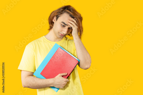 Young man Prep Student with long hair. Portrait of a guy on a yellow background