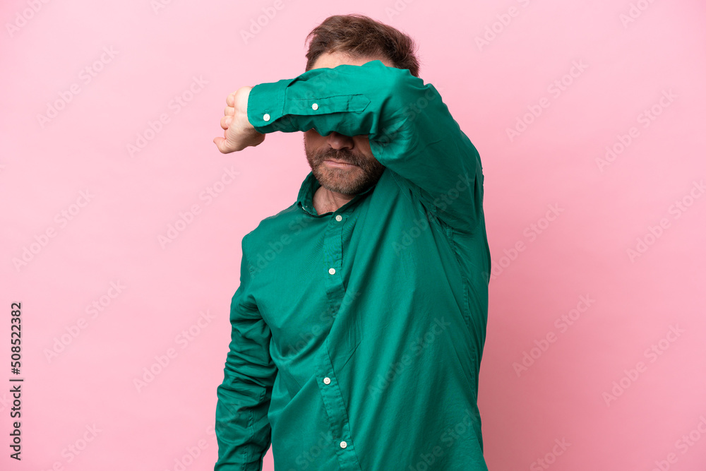 Middle age caucasian man isolated on pink background covering eyes by hands Middle age caucasian man isolated on pink background covering eyes by hands
