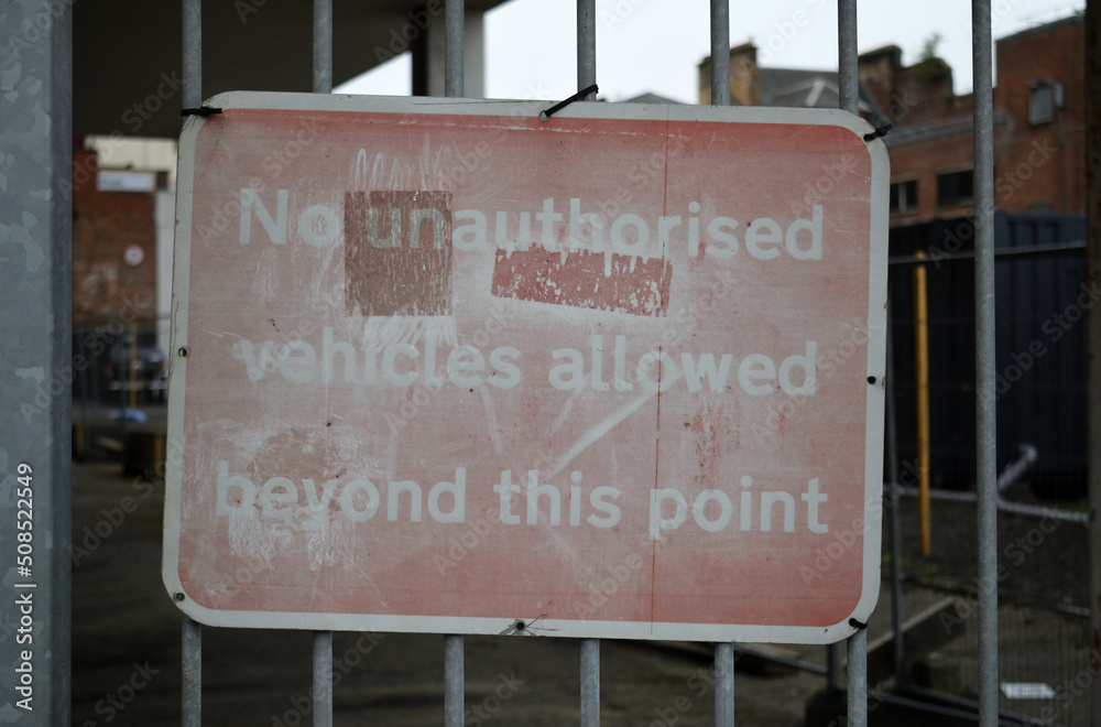 Obraz premium Old Faded Metal Sign on Gate of Industrial Yard in Close Up