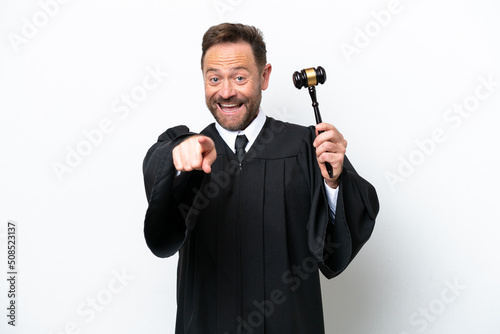 Middle age judge man isolated on white background surprised and pointing front