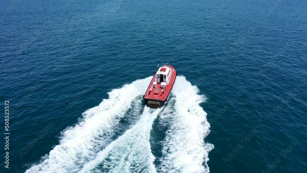 Aerial drone tracking video of red pilot boat cruising in high speed in Mediterranean deep blue sea offering navigational aid to ships Aerial drone tracking video of red pilot boat cruising in high speed in Mediterranean deep blue sea offering navigational aid to ships