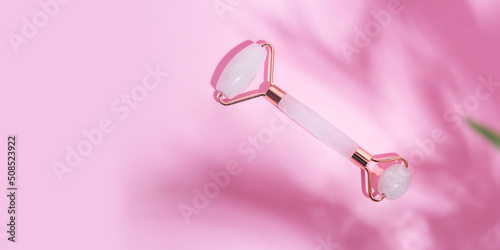 Facial roller from pink quartz,makeup concept,large banner with copy space.