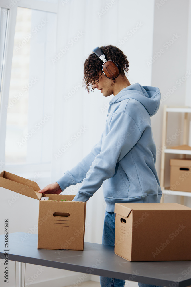 portrait of a man unpacking things from boxes in the room interior
