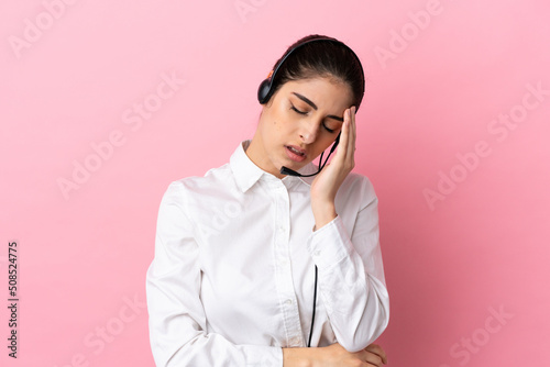 Obraz na płótnie Young telemarketer over isolated background with headache