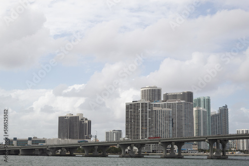 Some buildings and a bridge in Miami, Florida with a sky full of clouds in the background