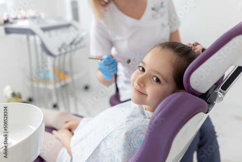 Little beautiful girl at the dentist looking at the camera and smiling