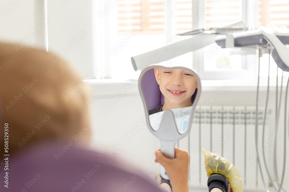 Child patient looking at her teeth through the mirror Child patient looking at her teeth through the mirror
