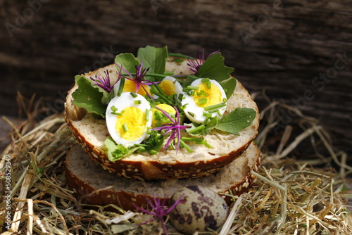 Roll topped with boiled quail eggs in hay nest
