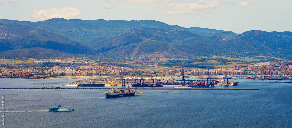 Panoramic view of the industrial port of Algésiras in the south of Spain - Giant cranes loading containers onto maritime freighters in the Mediterranean Sea