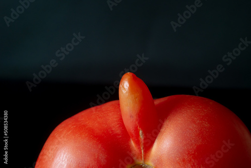 Mutated tomato on a dark background. Male penis size concept