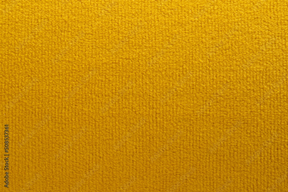 wide yellow upholstered armchair with fabric upholstery on wooden legs in retro style wide yellow upholstered armchair with fabric upholstery on wooden legs in retro style