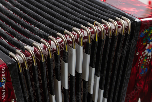 folklore musical instrument, handmade Russian accordion with painting and inlay, isolated on a white background