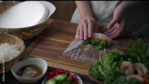 asian women hands wrapping Vietnamese summer roll