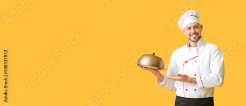 Handsome male chef on yello...