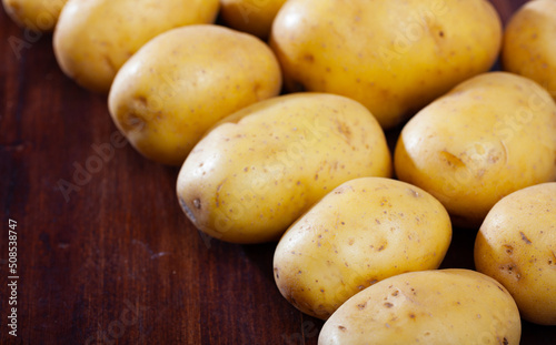 Raw potato tubers on a wooden table. High quality photo photo