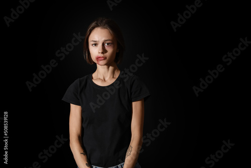 Bruised young woman on blac...