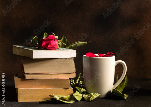 A pile of books and a cup of flower tea. Loving concept of study. Background for bookstores, libraries and book clubs