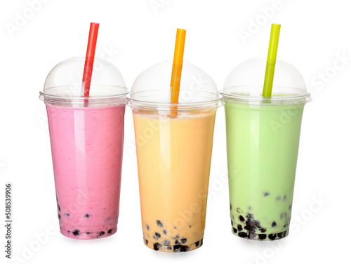 Plastic cups of different tasty bubble tea on white background