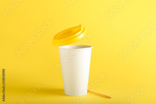 Takeaway paper cup on yello...