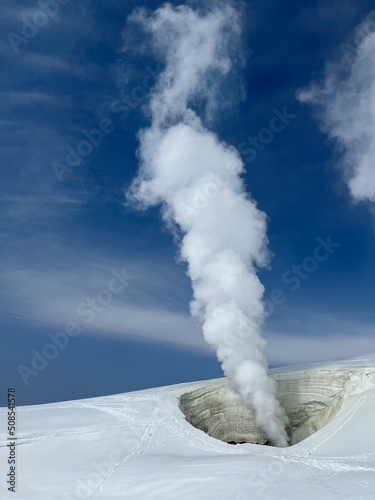 Steam rising from natural fumarole in snowy winter volcano landscape Asahidake Hokkaido Japan photo